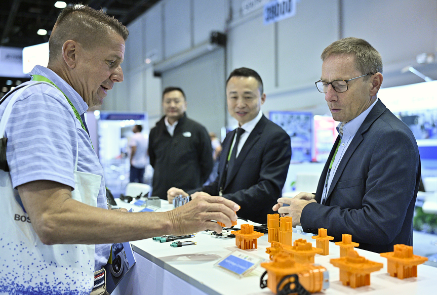 Trade show attendees exploring moldmaking innovations